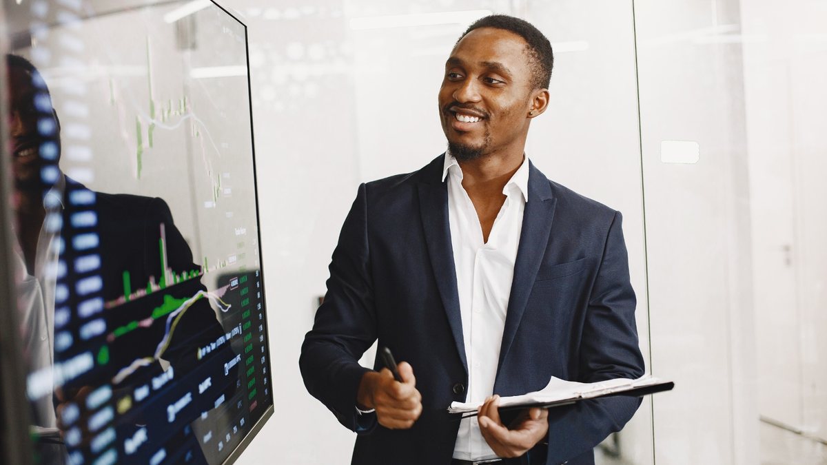 Assessor de investimentos analisando gráficos em um escritório